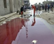 Iraqi workers clean debris near a large pool of blood at the scene of a suicide attack in the city of Hilla, 2005. A suicide bomber detonated a car near police recruits and a crowded market, killing 115 people and wounding 148 in the single bloodiest atta from silanka atta