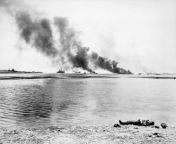 Burning Japanese ships in Tanapag Bay in the Garapan region of Saipan and the body of a dead Japanese soldier on the shore. July 6th 1944 from lorena and the land of ruins dead