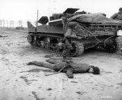 As a German lies dead in the street, American G.I.s inspect an American Stuart tank captured and put to use by German forces before the town fell to troops of the U.S. Ninth Army. Rheindahlen, Germany. 27 February 1945. from american nacked dance