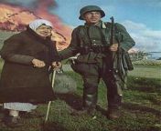 A German soldier stands with an elderly Russian woman as her village burns behind her. Soviet Union, Summer 1941. from village sister breastfeeding her