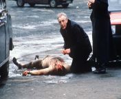 Catholic Priest giving last rites to a British soldier who was stripped naked and shot by the IRA. Belfast, 1988. from african woman stripped naked showing private part