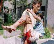 An aid worker carrying a wounded 11 year old girl to a hospital, Bosnian Genocide, 1995 from old dadx 70to80 pesent hospital