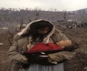 A Kurdish refugee mother looks at her dead baby for the last time during the exodus of millions of Iraqi Kurds in 1991 after Saddam chased them out of the country to Turkey and Iraq for their uprising during the first Gulf War. 150,000 died on the way fro from saddam husein digantung