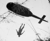 The body of an American paratrooper killed in action in the jungle near the Cambodian border is raised up to an evacuation helicopter in War Zone C, Vietnam in 1966.[1024985] from romance in the jungle